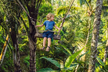 Bali Adası, Endonezya avucunda ile ormanda salıncak üzerinde mutlu çocuk
