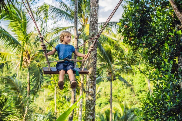 Bali Adası, Endonezya avucunda ile ormanda salıncak üzerinde mutlu çocuk