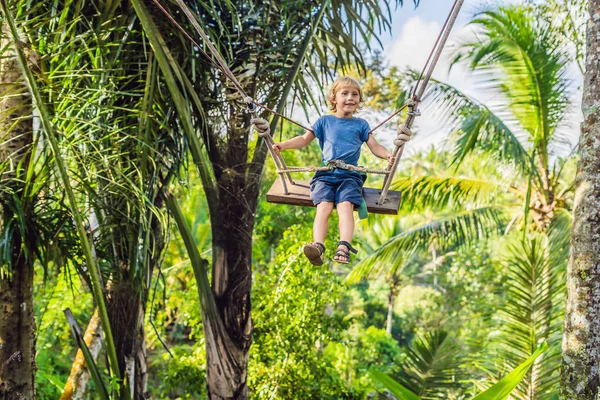 Bali Adası, Endonezya avucunda ile ormanda salıncak üzerinde mutlu çocuk