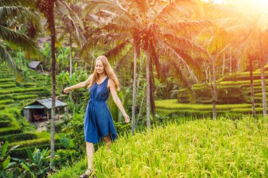Yeşil cascade pirinç alan çiftliğinde, Tegalalang, Bali, Endonezya yürüyen genç kadın.