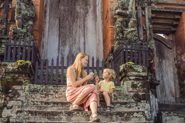 Anne ve oğlu turist Taman Ayun Tapınağı merdivenle poz. Bali, Endonezya