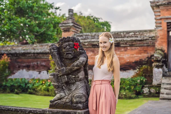 若い女性観光寺院タマンアユン インドネシア バリ島で古代彫刻の横にポーズ — ストック写真
