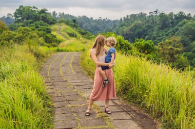 Anne holding oğul ve her diğer, Campuhan Ridge yürümek, Bali adlı arıyorsunuz