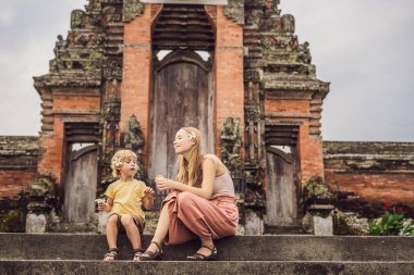 Anne ve oğlu turist Taman Ayun Tapınağı merdivenle poz. Bali, Endonezya
