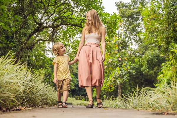 Mom and son are walking in the tropical park — Stock Photo, Image