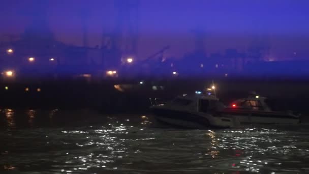 一艘警车在夜间在港口寻找罪犯。救援服务的工作的概念在水 — 图库视频影像