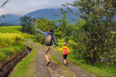 Baba ve oğlu volkan yakınındaki yolda Bali Adası'nda yürüyüş