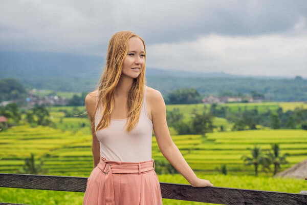 Young woman traveler posing by Jatiluwih Rice Terraces, Bali, Indonesia