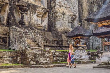 Anne ve oğlu Gunung Kawi arka plan üzerinde. Antik tapınak kral mezarları ile taş oyma. Bali, Endonezya. Çocuk kavramı ile seyahat