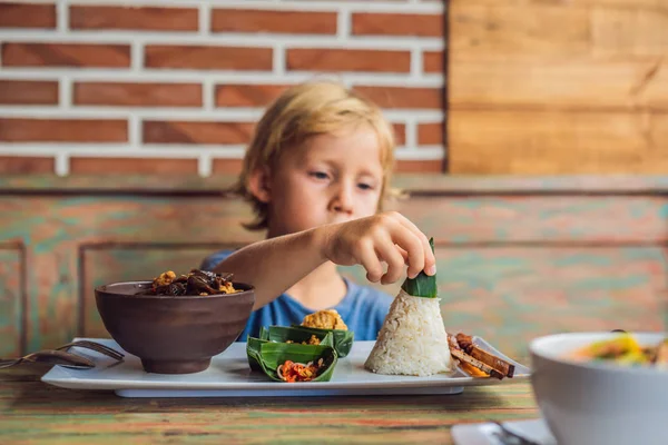 カフェご飯 魚のフライと伝統的なアジア料理で食べる少年 — ストック写真