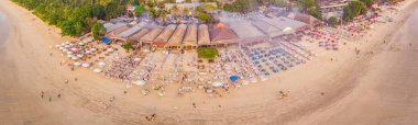 Aerial view of Balinese Jimbaran beach with seafood restaurants, hotels and tourists clipart