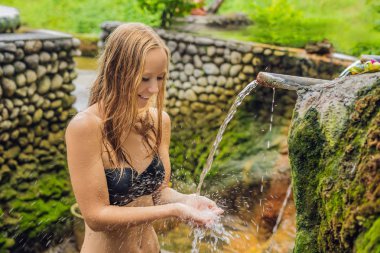 Belulang kaplıca havuzu su akışı, Bali, Endonezya ile poz bikini giyen genç kadın
