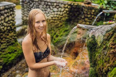 Belulang kaplıca havuzu su akışı, Bali, Endonezya ile poz bikini giyen genç kadın