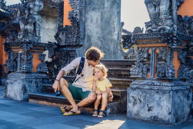 Baba ve oğul adımlar Bali, Endonezya Tanah Lot Tapınağı üzerinde oturan. 