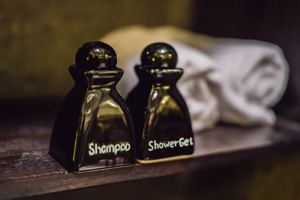 Close up view on the bottles with shampoo, shower gel and towels in the hotel bathroom — Stock Photo, Image