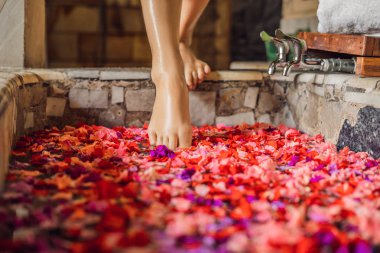 Spa Bath tropikal çiçek yaprakları ile yürüyen kadın ayakları