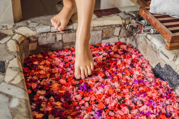 Voeten Van Vrouw Wandelen Spabad Met Bloemblaadjes Van Tropische Bloemen — Stockfoto