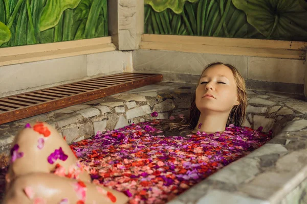 Jonge Vrouw Ontspannen Spabad Met Bloemblaadjes Van Tropische Bloemen Aroma — Stockfoto