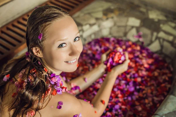 Junge Frau Genießt Wellnessbad Mit Blütenblättern Tropischer Blumen Und Aromaöl — Stockfoto