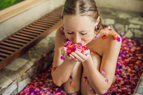 Νεαρή Γυναίκα Απολαμβάνοντας Μπανιέρα Πέταλα Από Τροπικά Λουλούδια Και Άρωμα — Φωτογραφία Αρχείου