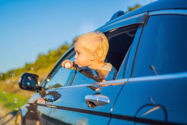 Çocuk araba penceresinde gezi kabarcıklar üfleme