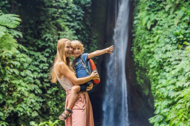 Anne ve oğlu Leke Leke şelale Bali Adası, Endonezya arka plan üzerinde sarılma