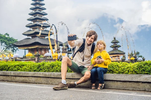 Baba ve oğul alarak Bali Adası, Endonezya Pura Ulun Danu Bratan hindu Tapınağı yakınındaki ateş
