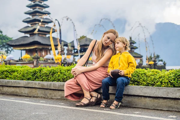 ママと息子のプラ ウルン ブラタン インドネシア バリ島のヒンズー教の寺院の近くに座って — ストック写真