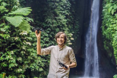 Adam dron tropikal bitki ve arka plan, şelale ile denetleme 