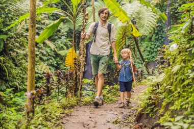 Baba ve oğul trekking sopa ile ormanda yürüyüş