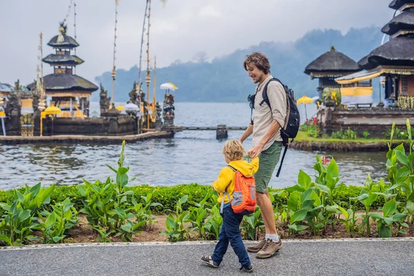 お父さんと息子のバリ水寺プラ ウルン ブラタンのバック グラウンドでウォーキング — ストック写真