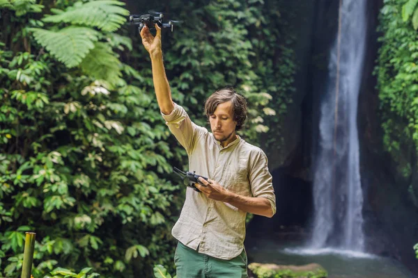 Hombre Controlando Dron Con Plantas Tropicales Cascada Fondo —  Fotos de Stock