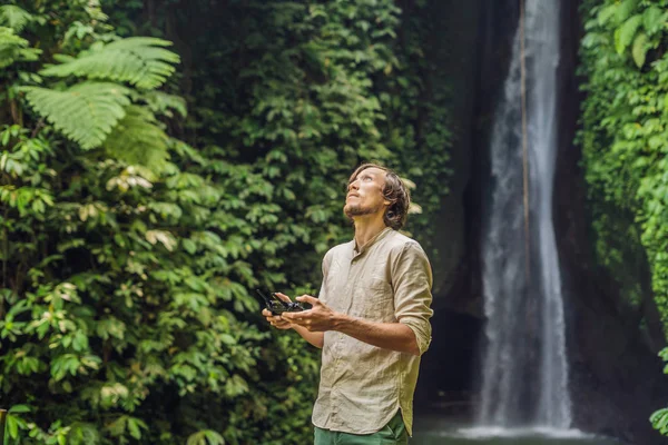 Человек Управляющий Дроном Тропическими Растениями Водопадом Заднем Плане — стоковое фото