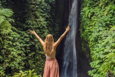 Genç kadın turist Leke Leke şelale Bali Adası, Endonezya arka plan üzerinde
