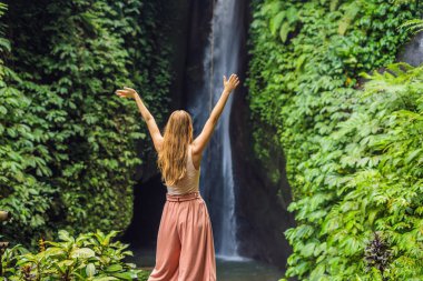 Genç kadın turist Leke Leke şelale Bali Adası, Endonezya arka plan üzerinde