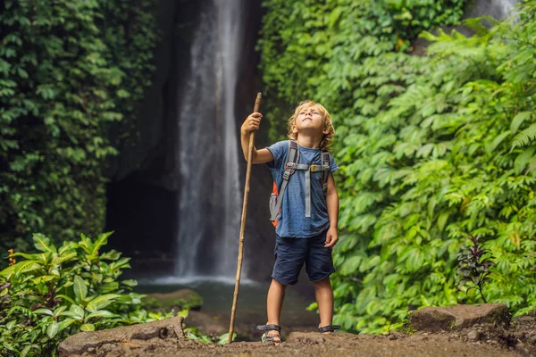 バリ島 インドネシアのラカレケ ラカレケ滝の背景にトレッキング スティックを持つ少年 — ストック写真