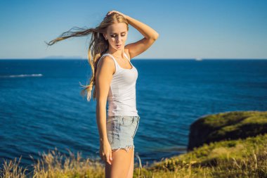 Genç kadın mavi deniz alandaki poz