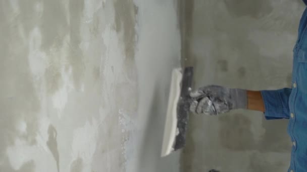 Медленный снимок молодого художника, накладывающего шпаклевку на стены — стоковое видео
