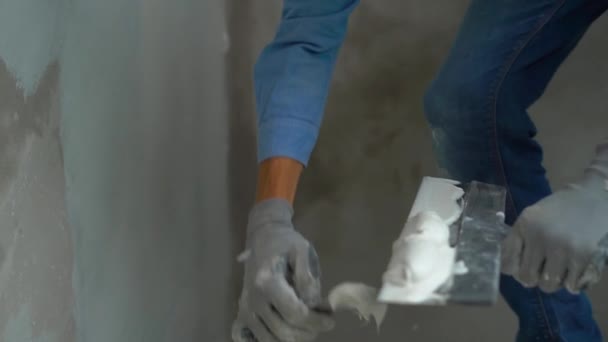 Zeitlupenaufnahme eines jungen Malers, der Kitt auf die Wände aufträgt — Stockvideo