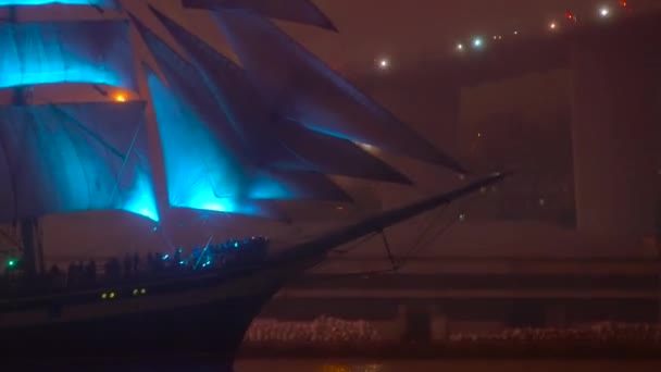 Een groot zeilschip met blauwe verlichting zeilen zwemt langs de haven. Het concept van grote menselijke inspanningen en ambities — Stockvideo