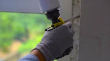 Genç bir adam Plastik pencere yükleme Slowmotion vurdu. Yükleyici dikişleri köpük ile doldurur.
