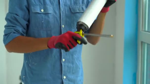 Mladý muž, instalace plastových oken. Instalační program se třese balónek s montážní pěnou — Stock video