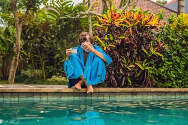 Peçeteyle havuzu oturan ve sıcak çay içme hayal kırıklığına hasta adamı 