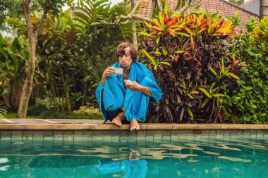 Peçeteyle havuzu oturan ve sıcak çay içme hayal kırıklığına hasta adamı 