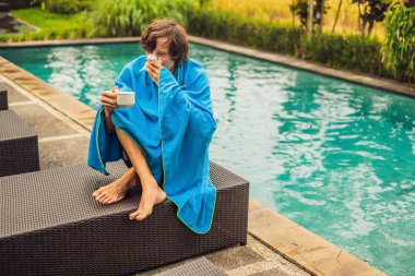 Havuzu oturan ve peçete ile burun üfleme ve sıcak çay içme hasta adamı 