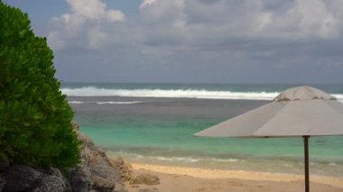 Seaside fırtınalı dalgalar, ağaç ve bulutlu gökyüzü ile tente ile 