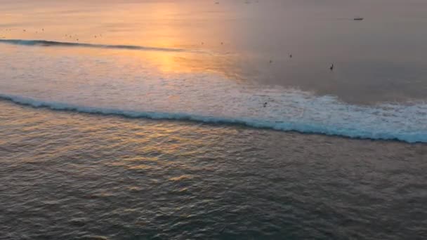 Luchtfoto slow-motion shot van een plek surfen op een tropisch eiland bij zonsondergang — Stockvideo