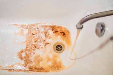 Kirli kahverengi akan su musluk beyaz lavabo içine düşen