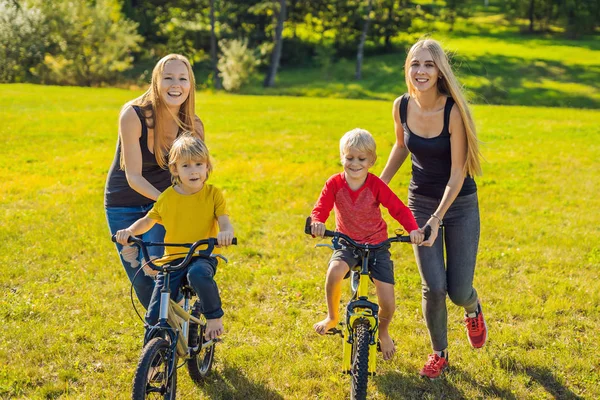 Δύο Μητέρες Ευτυχισμένος Διδασκαλία Ενεργό Γιους Βόλτα Ποδήλατα Στο Πάρκο — Φωτογραφία Αρχείου