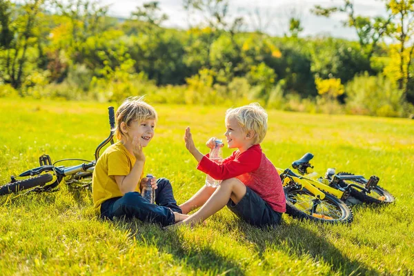 Küçük Çocuğu Çimenlerin Üzerinde Oturan Içme Parkı Içinde Bisiklet Sürme — Stok fotoğraf